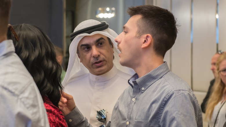 U.S. Air Force Staff Sgt. Evan Rauh, 386th Expeditionary Contracting Squadron contingency contracting officer, speaks with a local attendee at the Discover America week business speakers seminar at the Hyatt Regency Hotel in Kuwait City, Nov. 4, 2019. Airmen with the 386th ECONS discussed contract opportunities to local vendors. (U.S. Air Force photo by Tech. Sgt. Daniel Martinez)