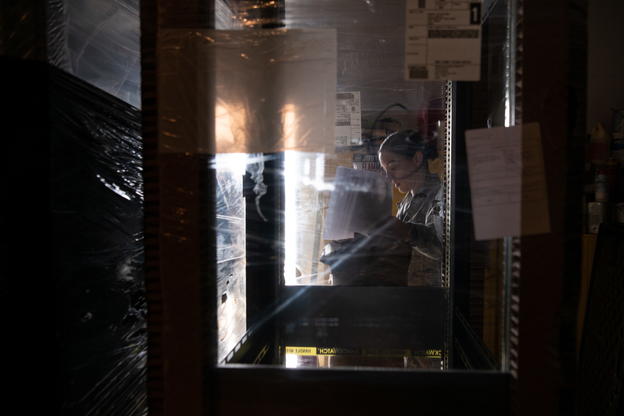 Tech. Sgt. Allison Dzon, cable antenna systems Airman for the 205th Engineering and Installation Squadron and team chief for the installation project, goes through an inventory list as she checks off the plastic-wrapped racks in a storeroom at Andersen Air Force Base in Guam on Sept. 9, 2019. The 205th EIS out of Oklahoma City had seven Airmen working to install ten CM-300/350 radios on racks in the 36th Operations Support Squadron air traffic control tower in Guam as part of the U.S. Air Force Air Traffic Control and Landing Systems Radio Replacement Program. (U.S. Air National Guard photo by Staff Sgt. Brigette Waltermire)