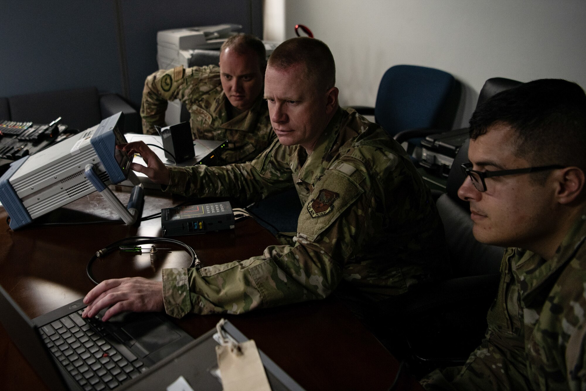 Tech. Sgt. Alan Ruiz (left), Regional Maintenance Center techinician for the Air Force Flight Standards Agency Pacific Regional Maintenance Center, Tech. Sgt. Robert Miller (center), Regional Maintenance Center team chief for the Air Force Flight Standards Agency Pacific Regional Maintenance Center, and Tech. Sgt. Austin Juergens (right), 205th Engineering and Installation Squadron (EIS) radar, airfield and weather systems work center supervisor, work to tune a CM-300 digital receiver that will be installed by the 205th EIS team in the 36th Operations Support Squadron air traffic control tower at Andersen Air Force Base in Guam on Sept. 15, 2019. The 205th EIS had seven Airmen working to install ten CM-300/350 radios in the 36th Operations Support Squadron air traffic control tower in Guam as part of the U.S. Air Force Air Traffic Control and Landing Systems Radio Replacement Program. (U.S. Air National Guard photo by Staff Sgt. Brigette Waltermire)