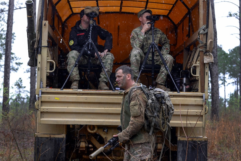 An Army sniper school graduate walks past spotters after completing a stalk course.