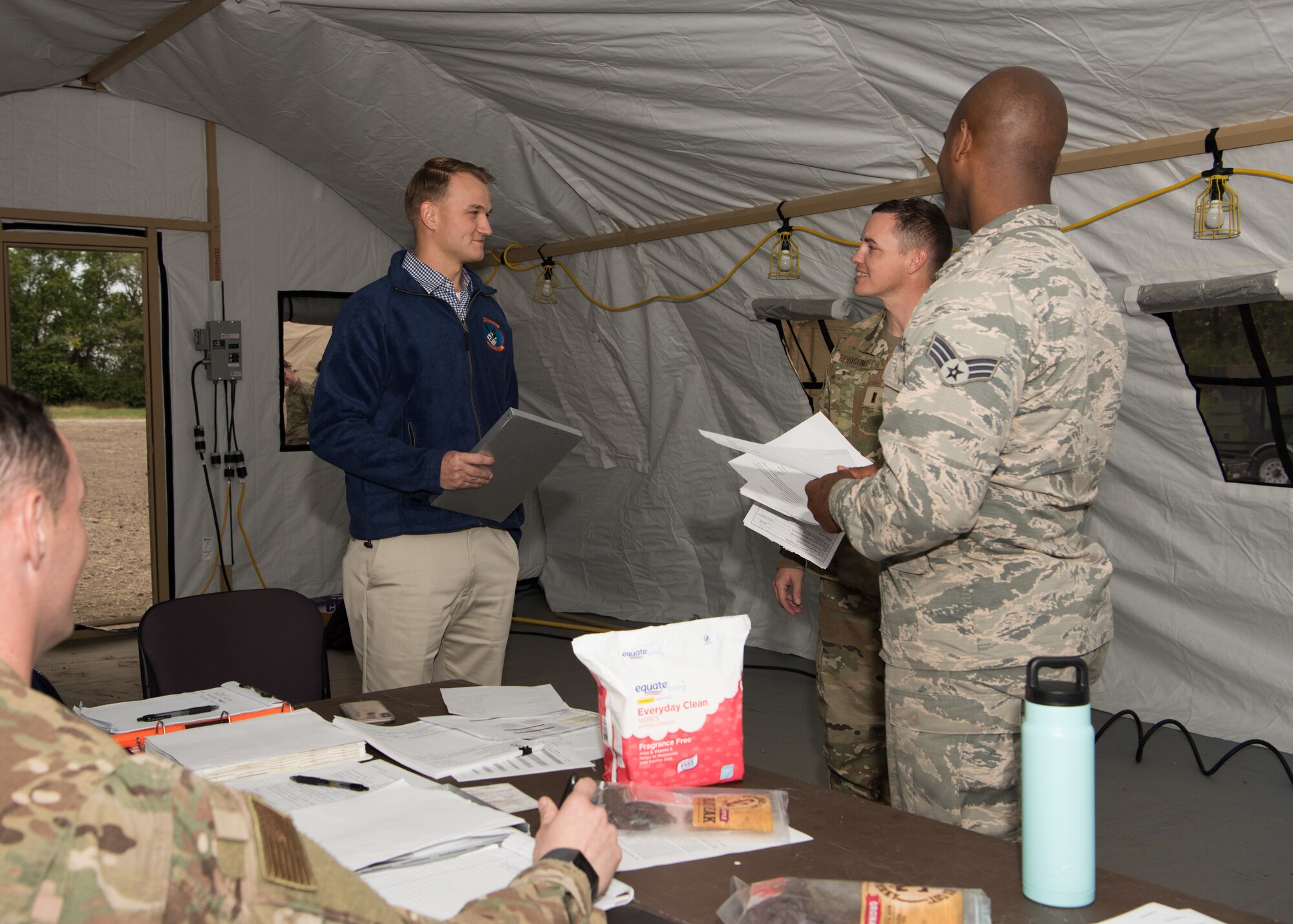 Second Lt. Shawn Edgecomb and Senior Airman Brandon Williams, both contracting administrators with the 509th Contracting Squadron, report to the command tent during a mock deployment exercise, Oct. 9, 2019, at Whiteman Air Force Base, Missouri. Squadron leadership reviewed and evaluated each team’s work throughout the exercise, which challenged them to support the setup of a notional deployed base in Mogadishu, Somalia. (U.S. Air Force photo by Airman 1st Class Parker J. McCauley)