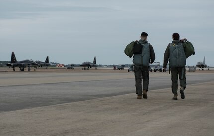 Vivienne Machi, Defense Daily reporter, and 1st Lt. Josh Burdge, 71st Fighter Training Squadron pilot, walk toward T-38A Talons during a familiarization flight at Joint Base Langley-Eustis, Virginia, Oct. 31, 2019. Machi experienced firsthand how 1st FW pilots train at JBLE. (U.S. Air Force photo by Airman 1st Class Sarah Dowe)