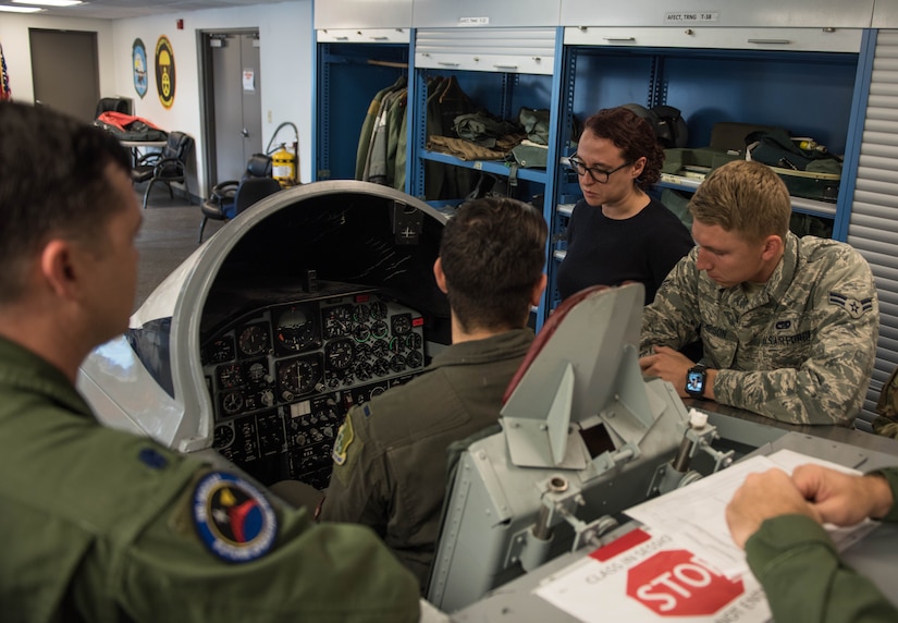 Vivienne Machi, Defense Daily reporter, and Airmen, learn about emergency procedures during SERE training at JBLE, Virginia, Oct. 31, 2019. The training is required before taking part in a familiarization flight. (U.S. Air Force photo by Airman 1st Class Sarah Dowe)