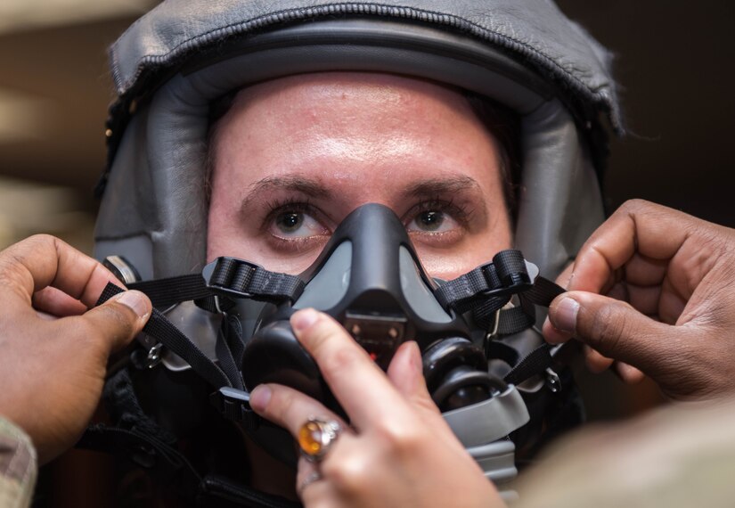 Vivienne Machi, Defense Daily reporter, gets fitted for a helmet and air mask before a familiarization flight at Joint Base Langley-Eustis, Virginia, Oct. 31, 2019. Machi flew in a T-38A Talon during an adversary air training with the F-22 Raptor. (U.S. Air Force photo by Airman 1st Class Sarah Dowe)