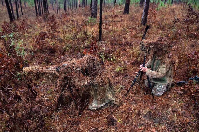 Army sniper school graduates setup a camouflage demonstration.