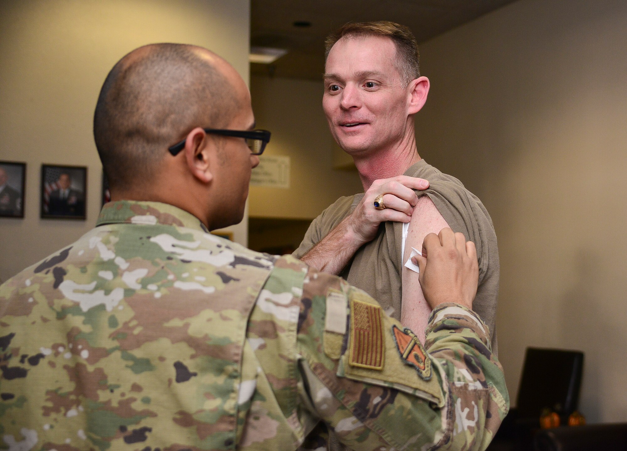 From left, U.S. Air Force Tech. Sgt. Mircho Plaza, 377th Medical Group Allergy and Immunology technician, gives U.S. Air Force Col. David S. Miller, 377th Air Base Wing commander, his influenza vaccination at Kirtland Air Force Base, N.M., Nov. 1, 2019. The flu shot is now available to active duty service members, who are required annually to receive the vaccine. (U.S. Air Force photo by Staff Sgt. Kimberly Nagle)