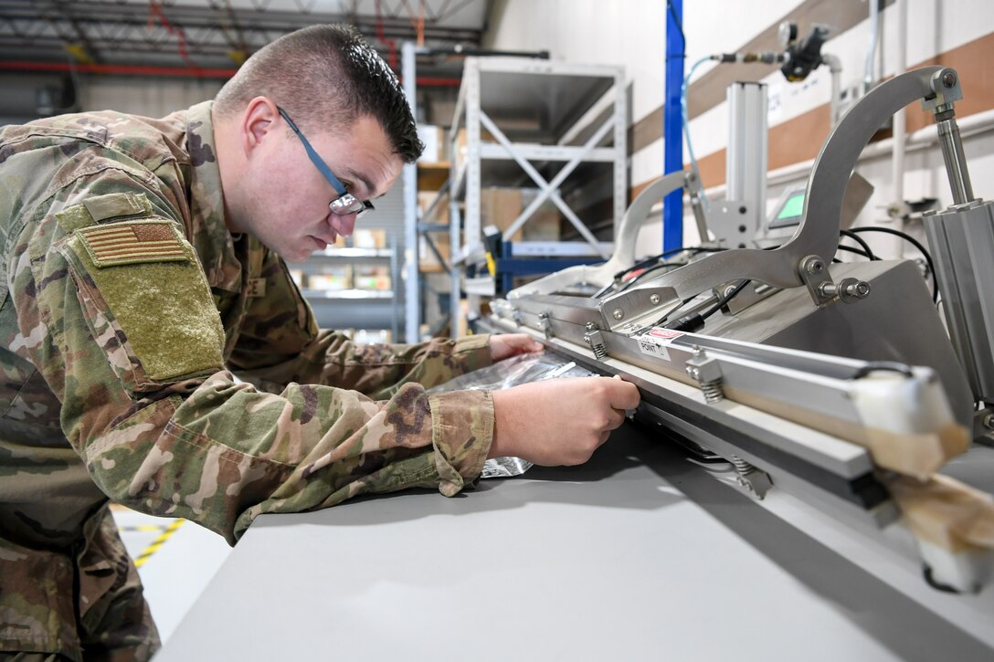 Senior Airman Alec Couture, munitions inspector with the 649th Munitions Squadron, heat seals a barrier bag, which holds assets for repackaging, with newly acquired equipment. The squadron recently purchased new electrostatic discharge workstations with Air Force Material Command squadron innovation funds, which has helped the squadron inspect incoming and outgoing munitions faster and safer.