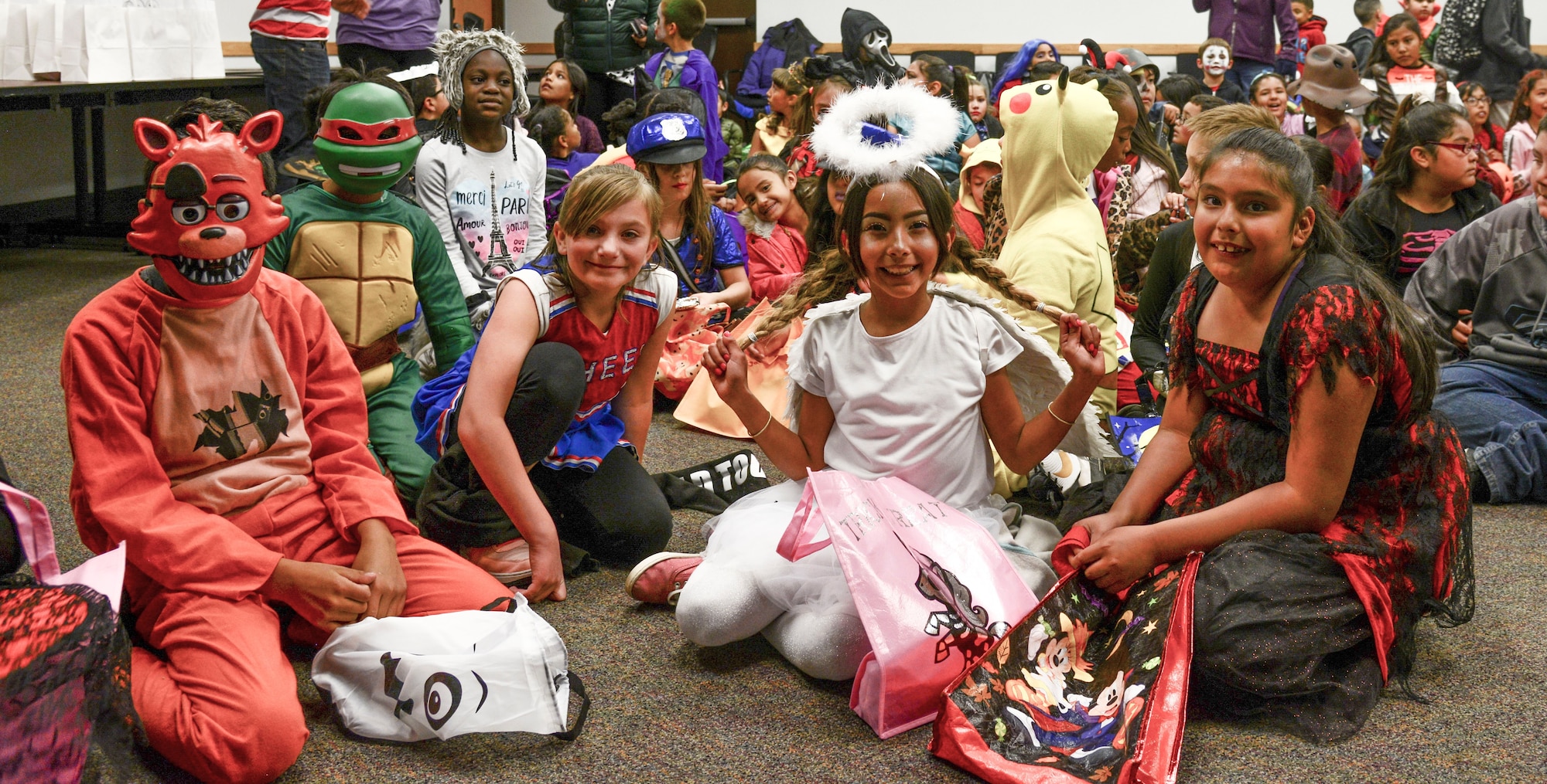 A group of Kirtland Elementary School students pose for a photo during a trick-or-treat event on Kirtland Air Force Base, N.M., Oct. 31, 2019. Each year, SMC invites the school to their Haunted Halloween event in which the entire building is filled with spooky decorations and hundreds of pounds of candy are passed out to costumed visitors.