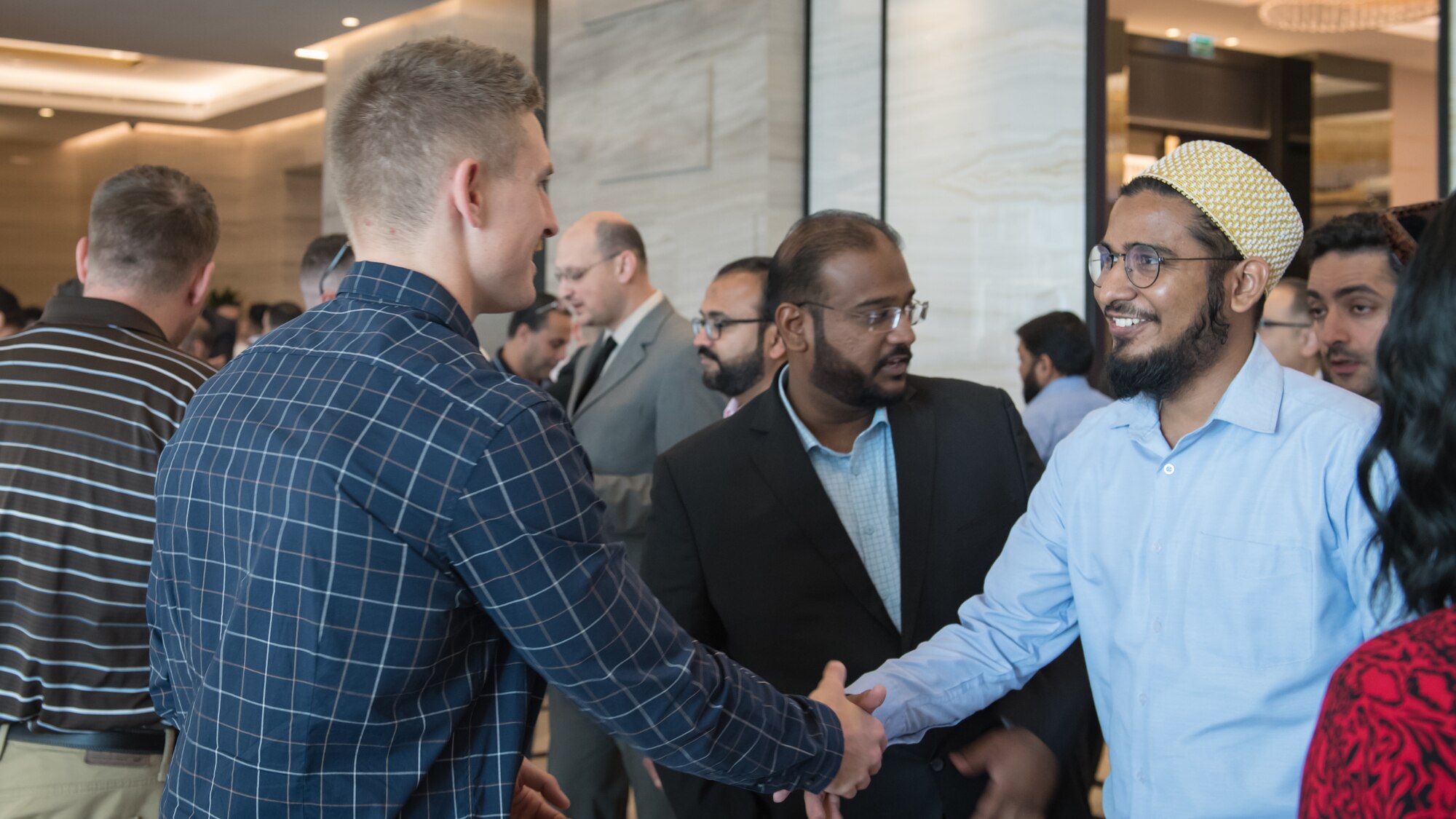 U.S. Air Force 1st Lt. Gavin McHenry, 386th Expeditionary Contracting Squadron base operations support flight commander and Air Force contract augmentation program administrative officer, shakes hands with an attendee at the Discover America week business speakers seminar at the Hyatt Regency Hotel in Kuwait City, Nov. 4, 2019. Airmen with the 386th ECONS discussed contract opportunities to local vendors. (U.S. Air Force photo by Tech. Sgt. Daniel Martinez)