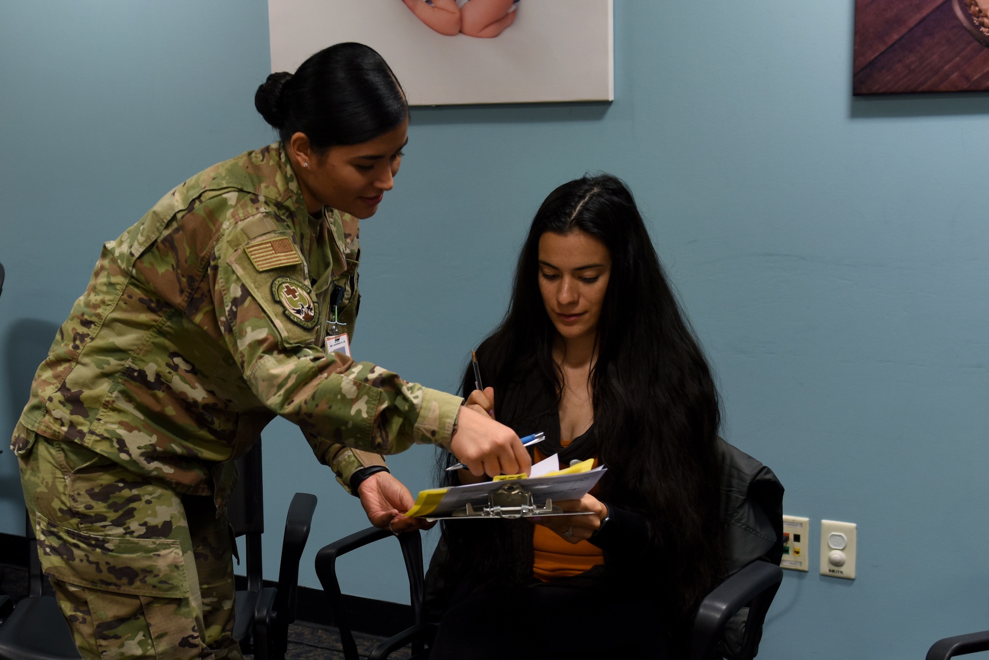 Senior Airman Jamie Eriksson, 48th Surgical Operations Squadron Obstetrics/Gynecologist medical technician, assists a patient during the Village Friends Group Obstetrics Care meeting at Royal Air Force Lakenheath, England, Oct. 25, 2019. The program provides prenatal care in a group setting of 8-12 women with similar due dates. (U.S. Air Force photo by Airman 1st Class Rhonda Smith)