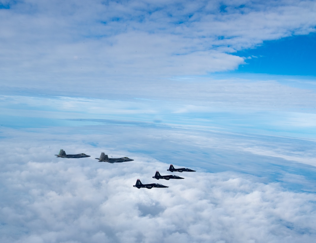 U.S. Air Force F-22 Raptors and U.S. Air Force T-38 Talons from the 1st Fighter Wing fly in formation of the Atlantic Ocean during training off the coast of Virginia, Oct. 30, 2019. The 1st Fighter Wing is home to the 94th Fighter Squadron, 27th Fighter Squadron and the 71st Fighter Training Squadron at Joint Base Langley-Eustis, Va. (U.S. Air Force Photo by Tech Sgt. Carlin Leslie)(Released)