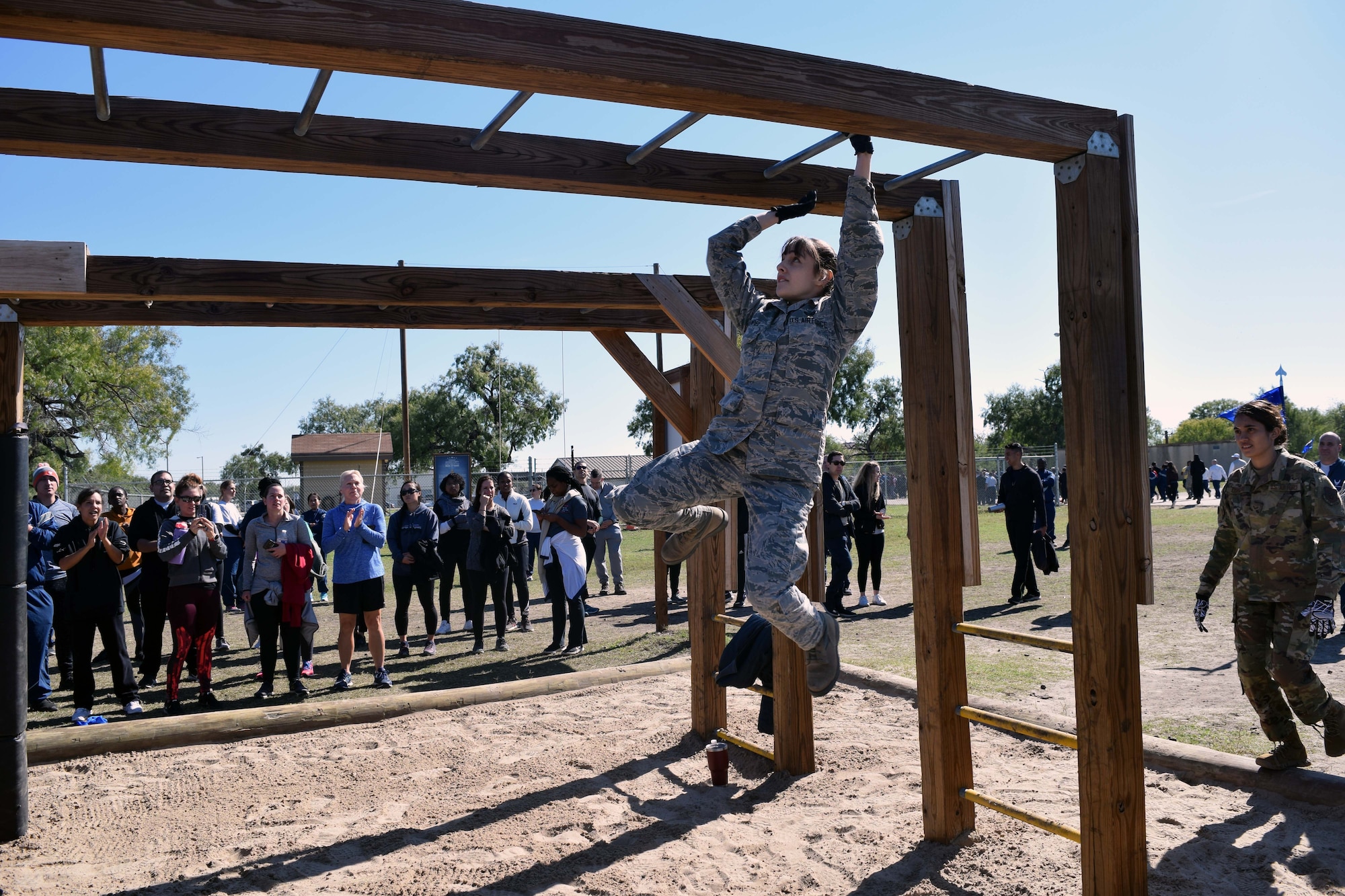 Staff Sgt. Alexis J. Kempel, 433rd Force Support Squadron force management technician, crosses the monkey bars during the 433rd Airlift Wing Resilience Tactical Pause at the Air Force Basic Military Training’s Basic Expeditionary Airman Skills Training site at the Medina Annex, Joint Base San Antonio-Lackland, Texas Nov. 3, 2019.