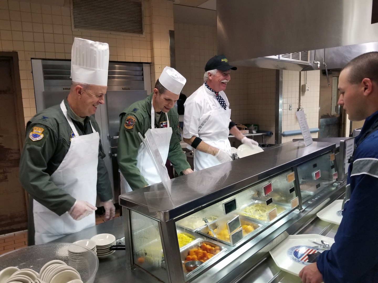 Col. James “JC” Miller, 433rd Operations Group commander, Lt. Col. Seth W. Asay, 733rd Training Squadron commander, and Dave Saylor, owner, Acadiana Café, prepare plates to serve to military members during the Thanksgiving feast at the Live Oak Dining Facility, Joint Base San Antonio-Lackland, Texas Nov. 2, 2019.