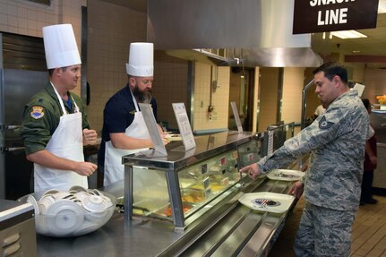 Lt. Col. William A. Dabney, 433rd Contingency Response Flight commander, and Honorary Commander Andrew Camplen, post commander, Pvt. Bruno Phillip Veterans of Foreign Wars, Post 688, serve food to 433rd Airlift Wing and 960th Cyberspace Wing members at the Live Oak Dining Facility at Joint Base San Antonio-Lackland, Texas Nov. 2, 2019.