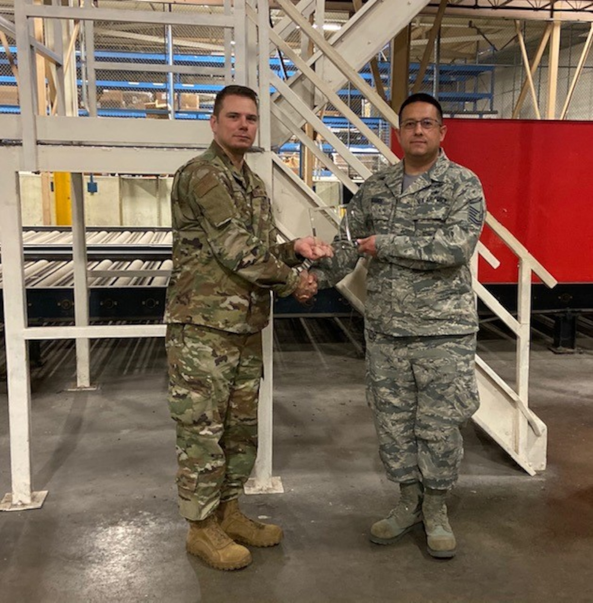 Master Sgt. Carlo Grande, 94th Aerial Port Squadron ramp services flight team chief, right, accepts the quarterly award for Senior NCO of the Quarter from Maj. James Fink, 94th APS commander at Robins Air Force Base, Ga.The award was presented on behalf of the wing commander and command chief. (Courtesy photo)