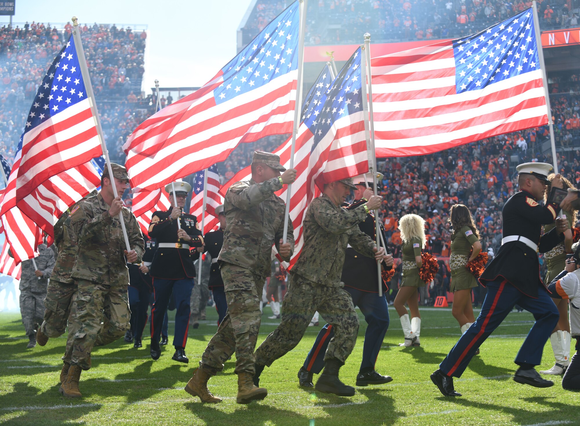 U.S. military service members run onto the field before the Denver Broncos Salute to Service game at Empower Field at Mile High in Denver, Nov. 3, 2019.