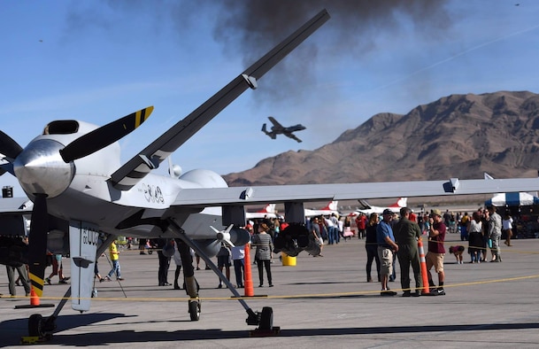 An MQ-9 Reaper assigned to the 432nd Wing/432nd Air Expeditionary Wing rests on the flightline as a A-10 Thunderbolt II flies overhead at the 2017 Aviation Nation Air and space Expo, Nov. 10, 2017, at Nellis Air Force Base, Nev. More than 165,000 spectators attended the event and celebrated the U.S. Air Force's 70th birthday. (Photo by Senior Airman Christian Clausen)