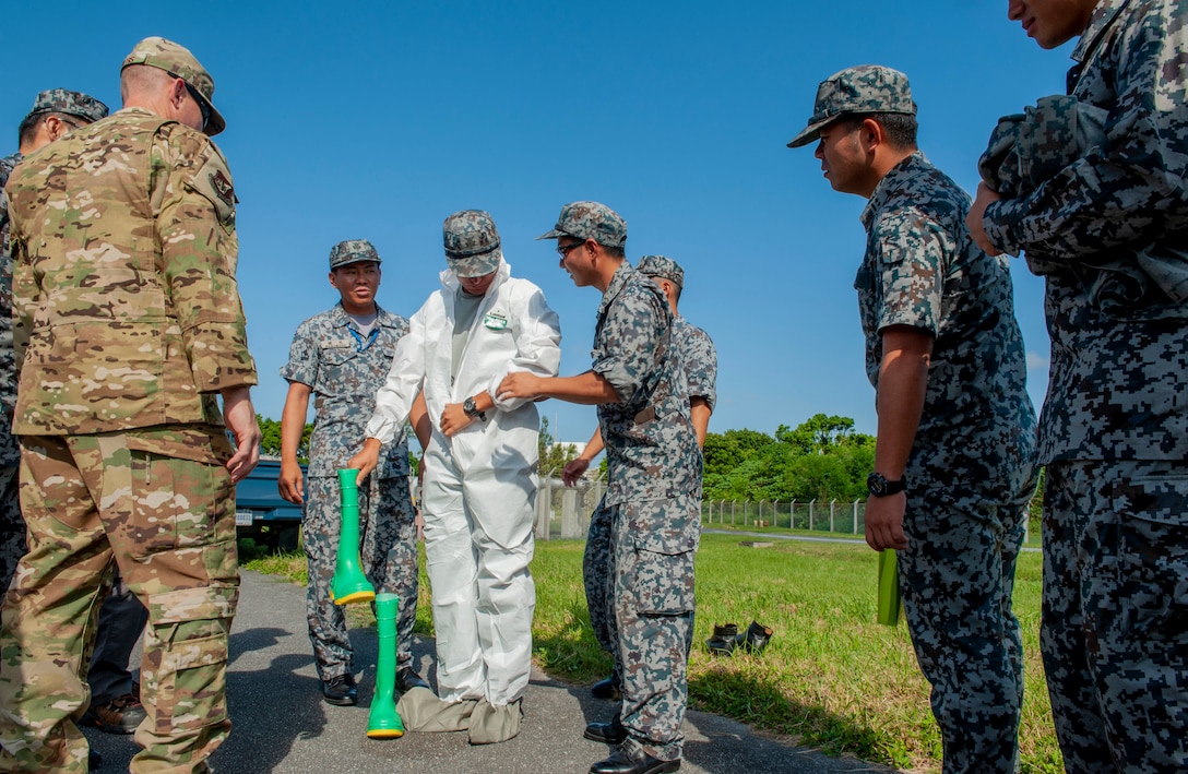 A member of Japan Air Self Defense Force, 9th Air Wing Base Supply Squadron, equips a level-A suit during a fuel spill exercise at Kadena Air Base, Japan, Oct. 25, 2019. The 18th Logistics Readiness Squadron commander invited more than 10 JASDF members from the 9th AW to observe the U.S. Armed Forces methods responding simulated fuel spill. (U.S. Air Force photo by Naoto Anazawa)