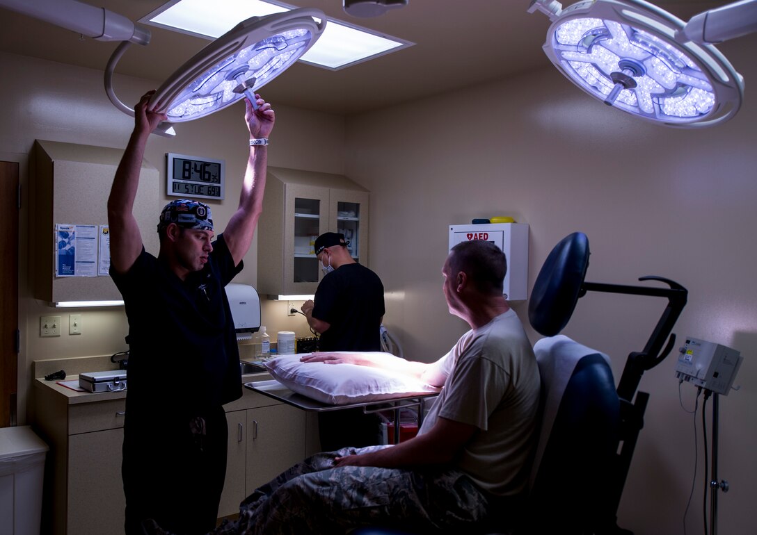 U.S. Air Force Maj. Thomas Beachkofsky, 6th Health Care Operations Squadron dermatologist, and Staff Sgt. Dalton Mace, 6th HCOS aerospace medical technician, prepare Lt. Col. Kurtis Kobes, a patient, for a procedure at MacDill Air Force Base, Florida, Nov. 5, 2019. With the help of a new dermatological analyzing software, Beachkofsky was able to diagnose a spot as an early stage of melanoma on Kobes and remove the area of skin before it could develop into deeper layers of skin. (U.S. Air Force photo by Senior Airman Adam R. Shanks)