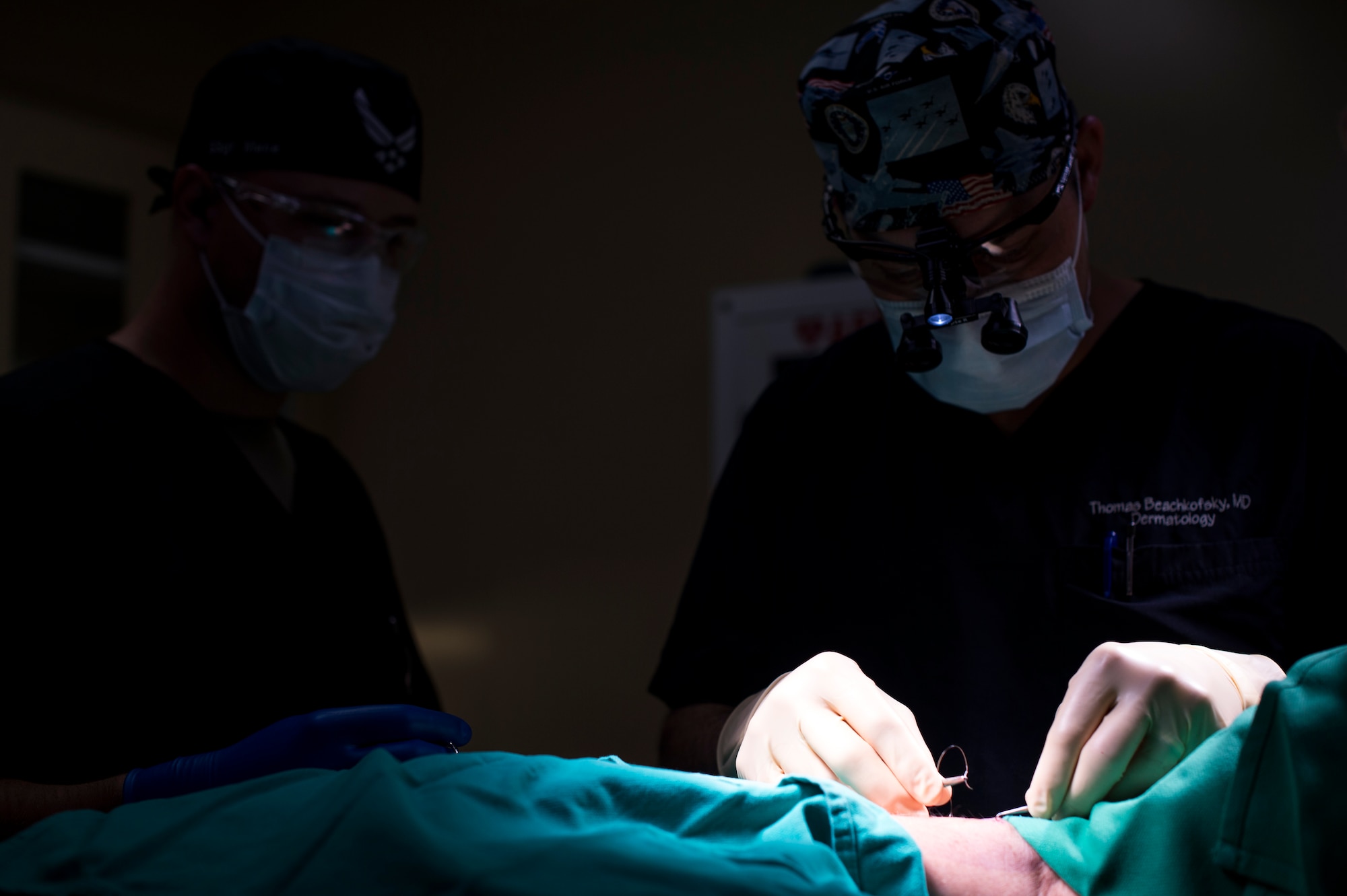 U.S. Air Force Maj. Thomas Beachkofsky, 6th Health Care Operations Squadron dermatologist, applies sutures to Lt. Col. Kurtis Kobes, a patient, during a procedure at MacDill Air Force Base, Florida, Nov. 5, 2019. With the help of a new dermatological analyzing software, Beachkofsky was able to diagnose a spot as an early stage of melanoma on Kobes and remove the area of skin before it could develop into deeper layers of skin. (U.S. Air Force photo by Senior Airman Adam R. Shanks)