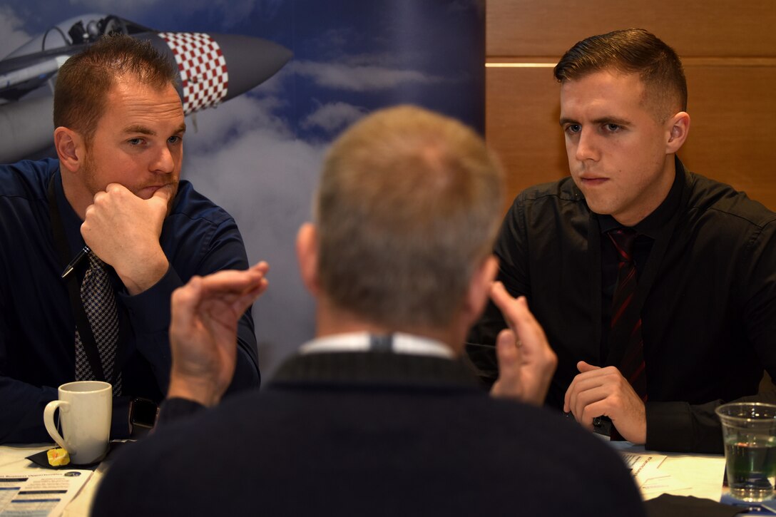 48th Contracting Squadron Airmen talk to an attendee at the London Stansted Airport Meet the Buyers event in Stansted, England, Nov. 5, 2019. This annual engagement provides organizations and contractors with a unique opportunity and cost-effective method of presenting their products and services directly to major first-tier contractors. (U.S. Air Force photo by Airman 1st Class Madeline Herzog)