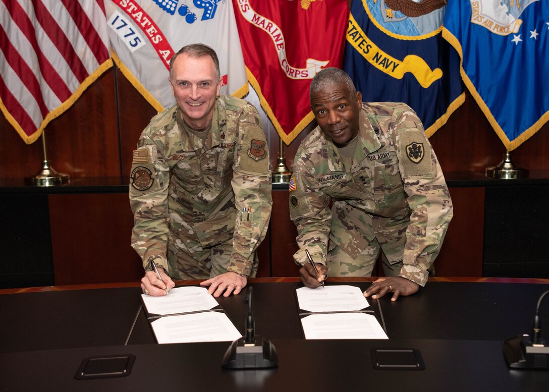Two lieutenant generals sign an agreement.