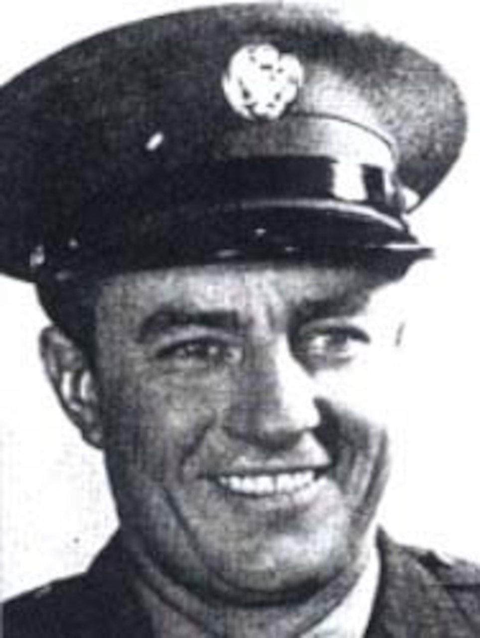A man wearing an Army dress cap smiles for a photo.