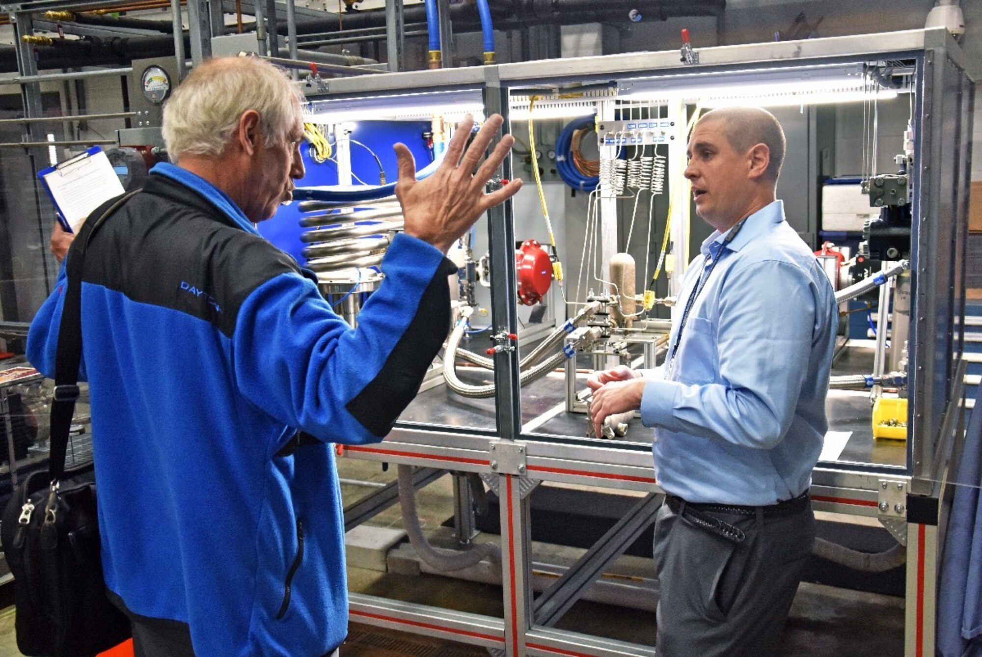 Marvin Gale, MAMLS Program Manager (left) and Grady Marcum, AFRL chemical engineer, discuss the new heat exchange tester during the capability’s kick-off tour, held Nov. 6. (U.S. Air Force Photo/Spencer Deer)