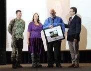 Capt. Torkelson, Danielle Larrew (Code 902.2), and Michael Zydron (Code 200) congratulate newly retired EDP Manager Fred Salanitro;