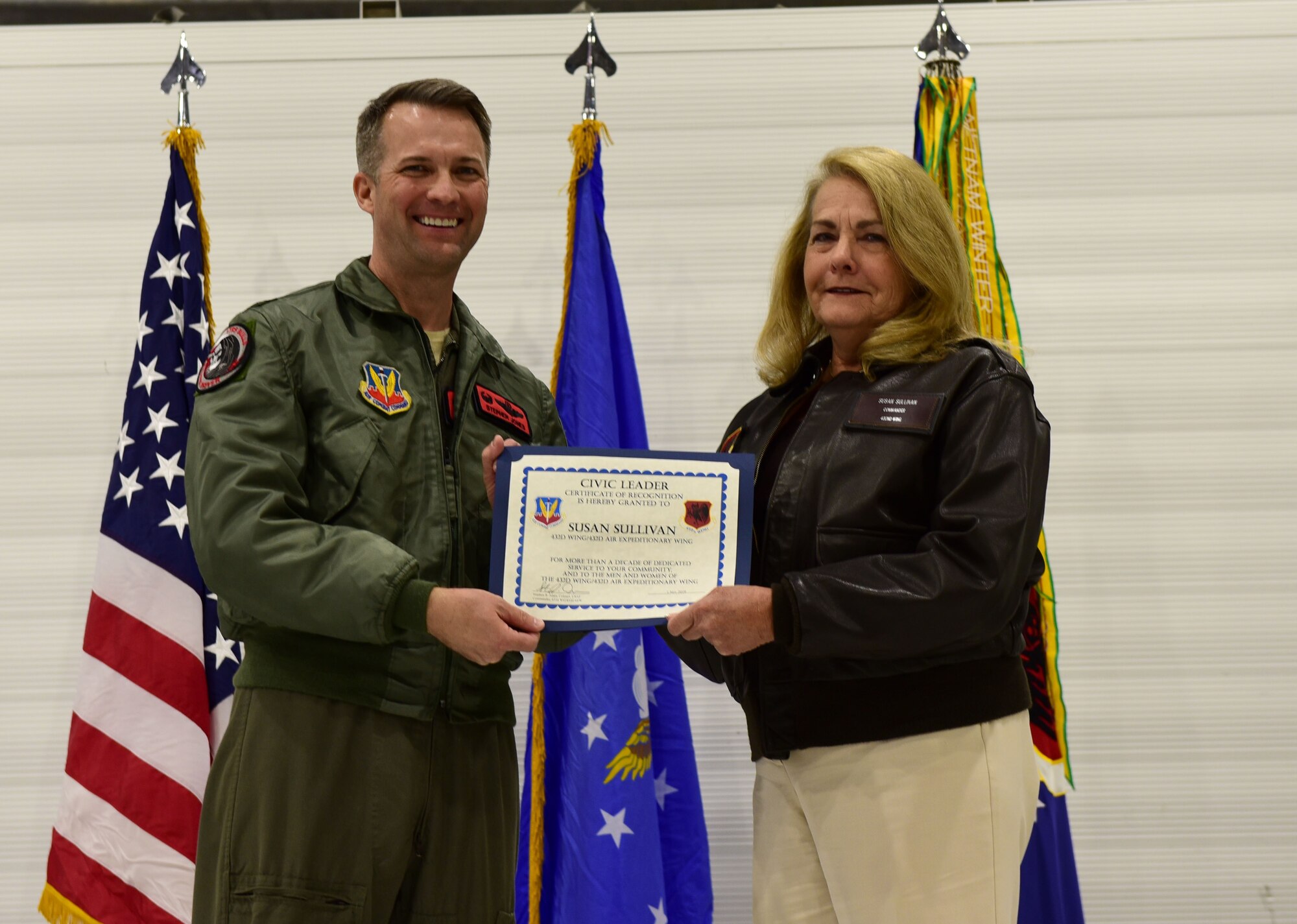 Col. Stephen Jones, 432nd Wing/432nd Air Expeditionary Wing commander, and Susan Sullivan, 432nd WG/432nd AEW civic leader, hold a certificate