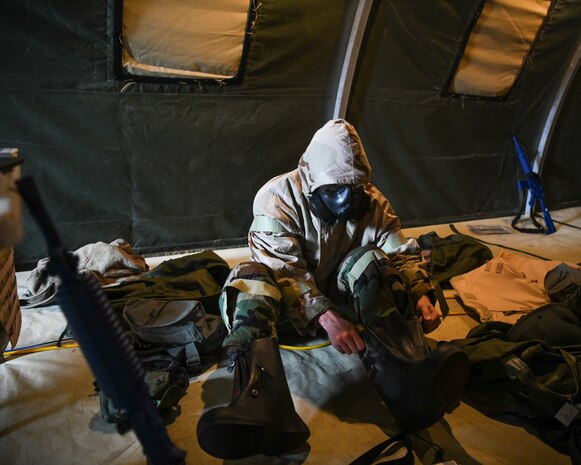 U.S. Air Force Staff Sgt. Garrett Sullivan, 628th Air base Wing Public Affairs photojournalist and exercise Unit Control Center dispatcher, dons Mission Oriented Protective Posture gear in response to a chemical attack exercise during Palmetto Challenge at McEntire Joint National Guard Base, S.C., Nov. 3, 2019. The goal of the exercise was to develop and maintain full-spectrum readiness and ensure JB Charleston’s Airmen were ready for rapid mobilization and able to support Air Mobility Command and DOD priorities. Both active-duty and reserve Airmen from the 628th Air Base Wing, 437th Airlift Wing and 315th Airlift Wing came together to train in operating in an austere environment. More than 140 Airmen took part in the global mobilization readiness exercise at McEntire Joint National Guard Base, and Pope Army Airfield, S.C.