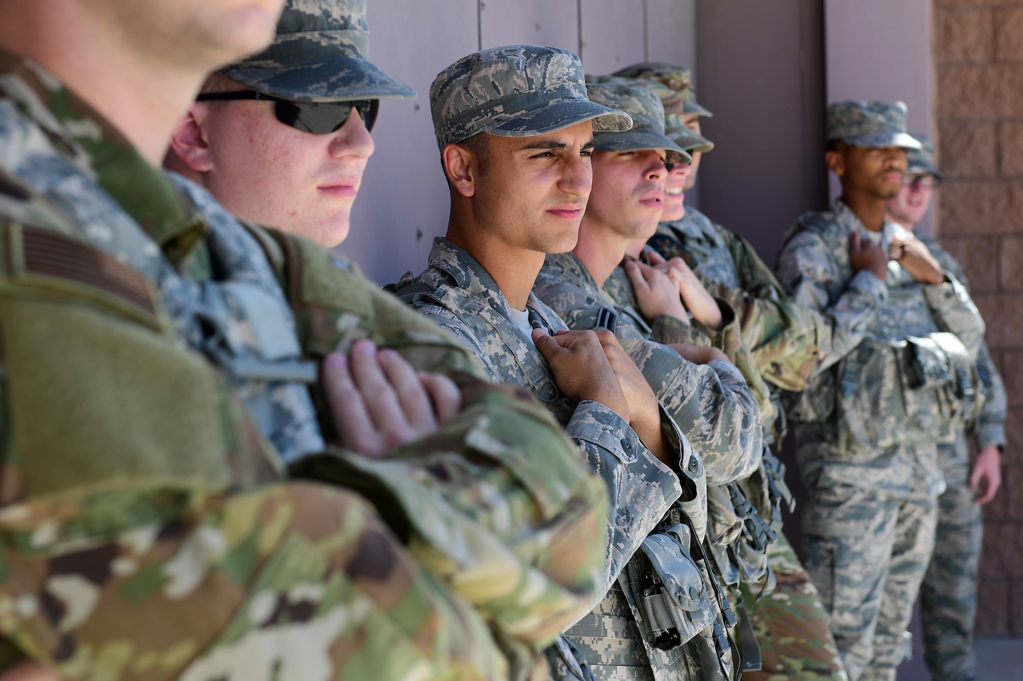 Eight Security Forces Airmen stand outside with their arms crossed
