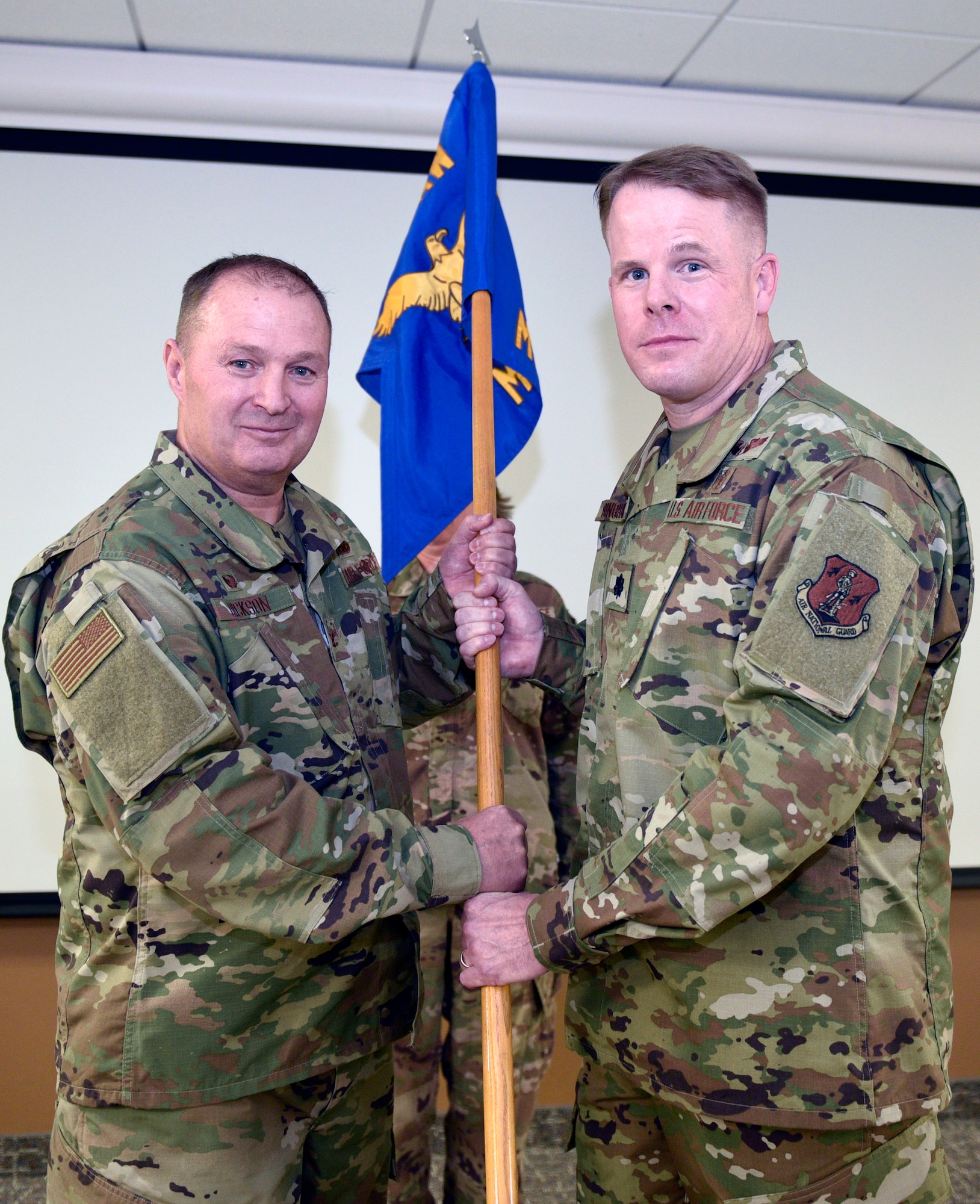 Lt. Col. Jonathan Bingham accepts the 120th Medical Group guideon from Col. Buel Dickson, 120th Airlift Wing Commander, as part of the change of command ceremony Nov. 3, 2019 here. Bingham was selected as the new commander of the 120th MDG.