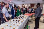 employees gather at cake table