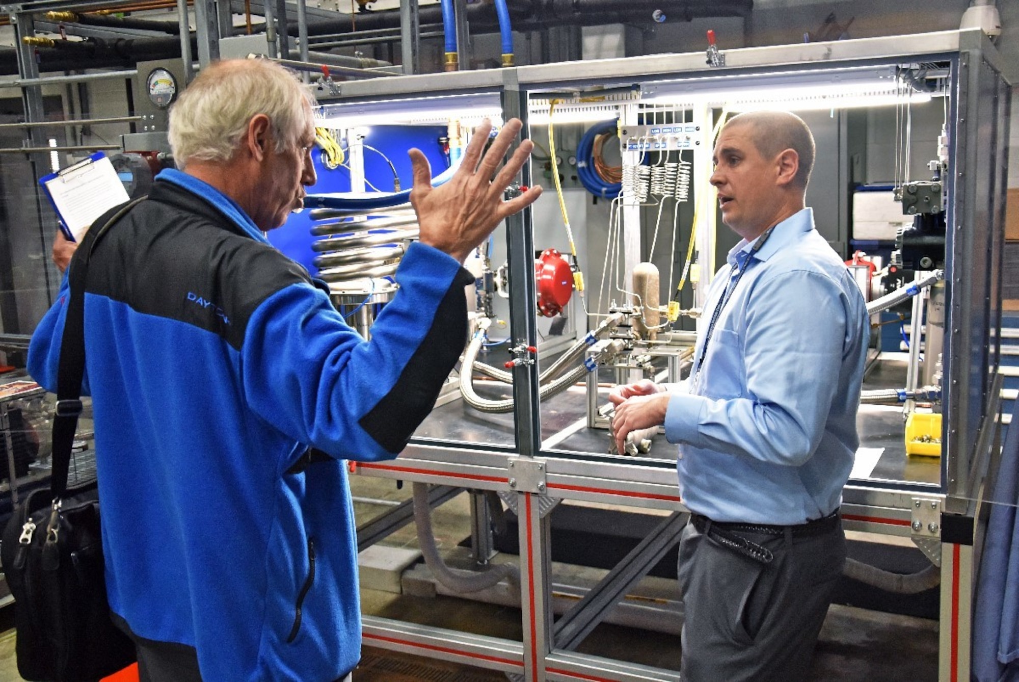 Marvin Gale, MAMLS Program Manager (left) and Grady Marcum, AFRL chemical engineer, discuss the new heat exchange tester during the capability’s kick-off tour, held Nov. 6. (U.S. Air Force Photo/Spencer Deer)