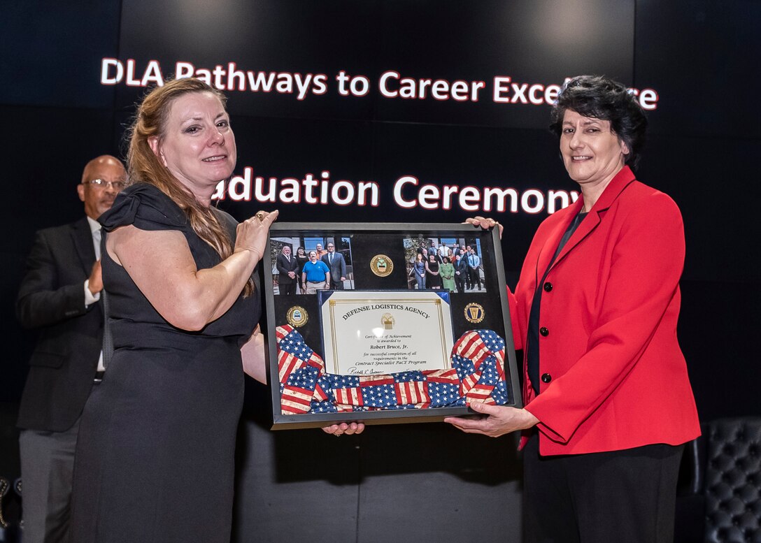 Woman accepts plaque from another woman