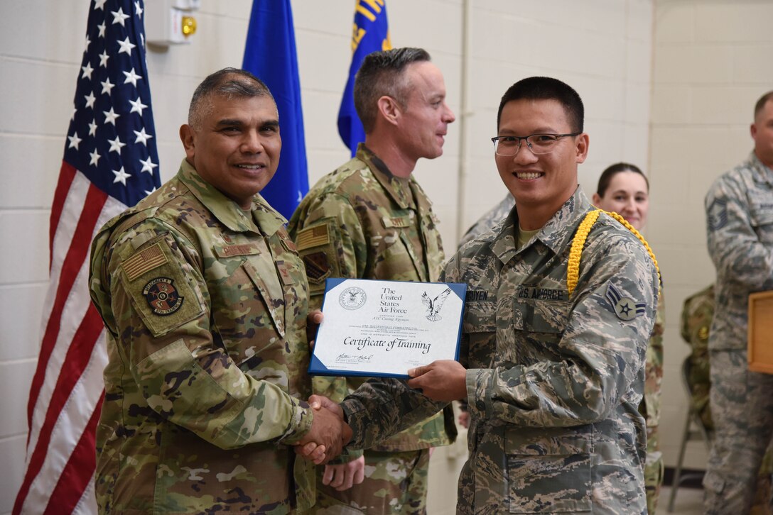 Col. Anthony Puente, 982nd Training Group commander, presents Airman 1st Class Cuong Nguyen, 931st Maintenance Squadron crew chief, with a Certificate of Training during the Mission Ready Airmen program graduation Nov. 5, 2019, at McConnell Air Force Base, Kan. Class 190021 was the first class to graduate as qualified KC-46 Pegasus crew chiefs. (U.S. Air Force photo by Airman 1st Class Marc A. Garcia)