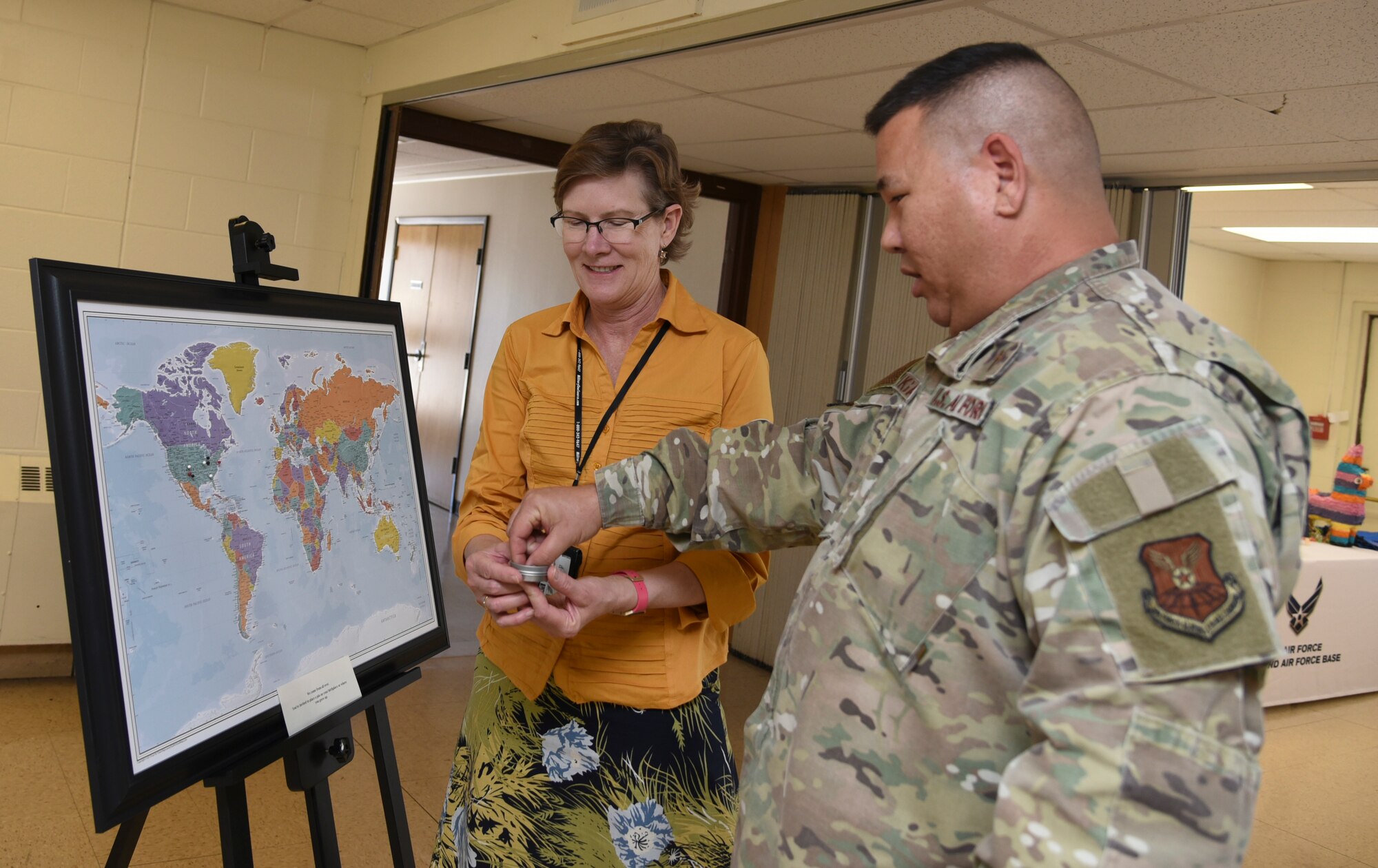 U.S. Air Force Chaplain (Maj.) Craig H. Nakagawa, 377th Deputy Wing chaplain, and Teresa L. Reinhard, 377th Air Base Wing community support coordinator, point out their location on a map at the Diversity Heritage Day event on Kirtland Air Force Base, N.M., Nov. 6, 2019.  Attendees placed a pin on their region of origin to highlight their diversity. (U.S. Air Force photo by Airman 1st Class Ireland Summers)