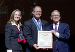 Man and woman pose with recipient