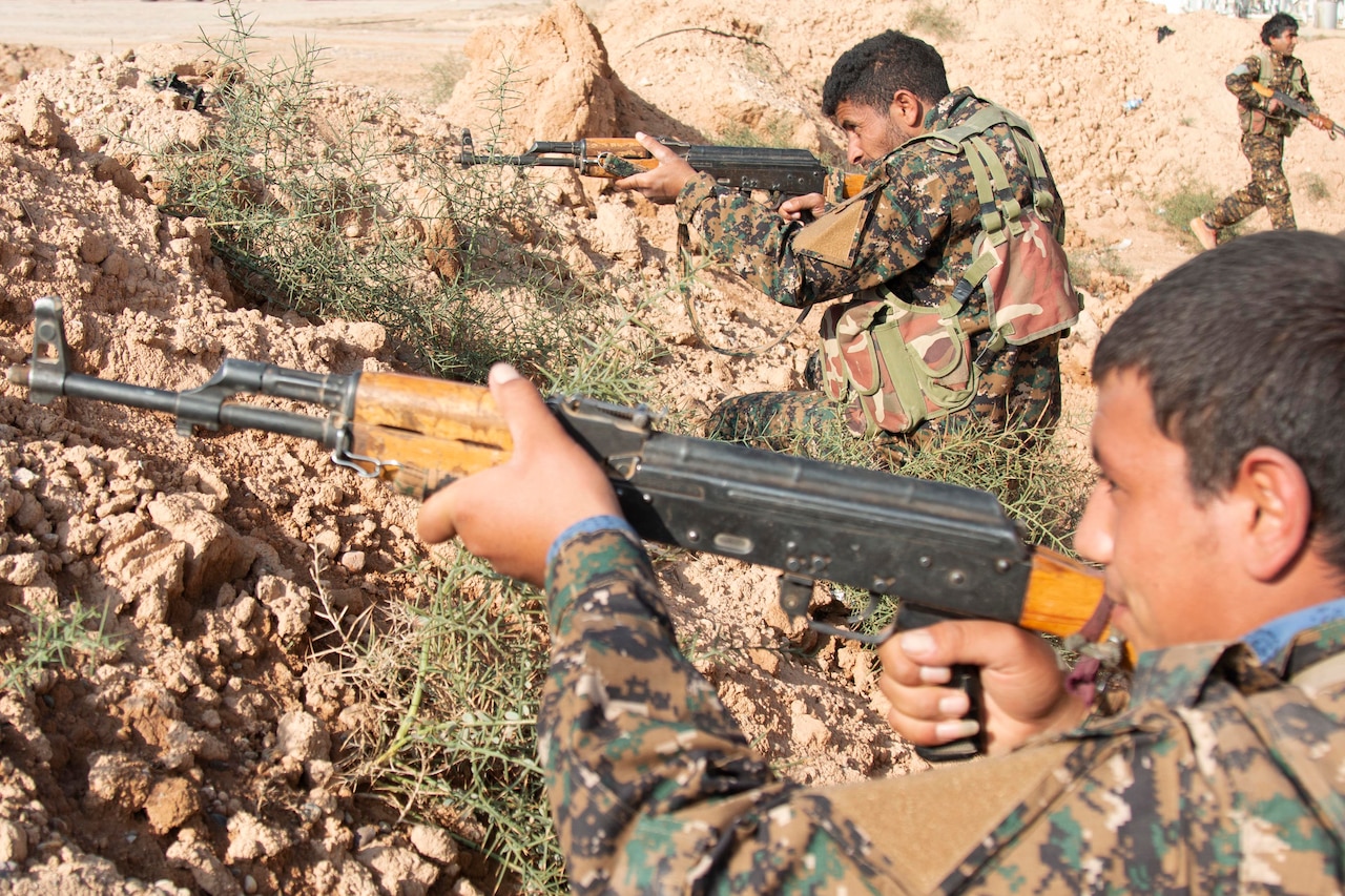 A uniformed service member aims his rifle.