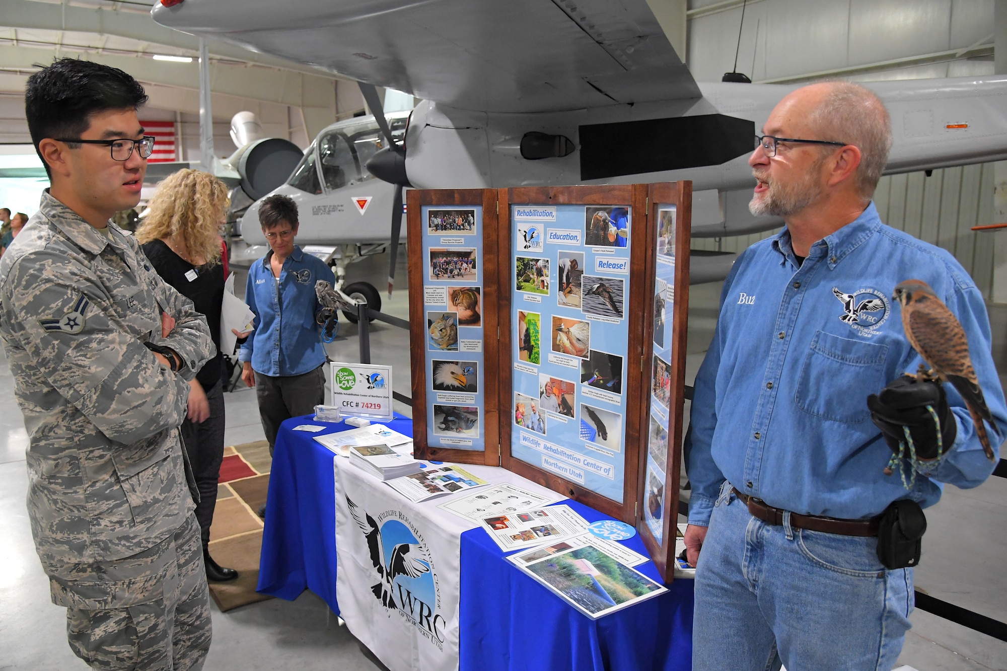 (Left to right) Airman 1st Class Andrew Lee, 729th Air Control Squadron, talks with Buz Marthaler, a representative with Wildlife Rehabilitation Center of Northern Utah, during the 2019 Combined Federal Campaign Kickoff and Exposition event held at the Hill Aerospace Museum Nov. 4, 2019, at Hill Air Force Base, Utah. The CFC is schedule to run Nov. 4 through Dec. 15 at Hill AFB. (U.S. Air Force photo by Todd Cromar)