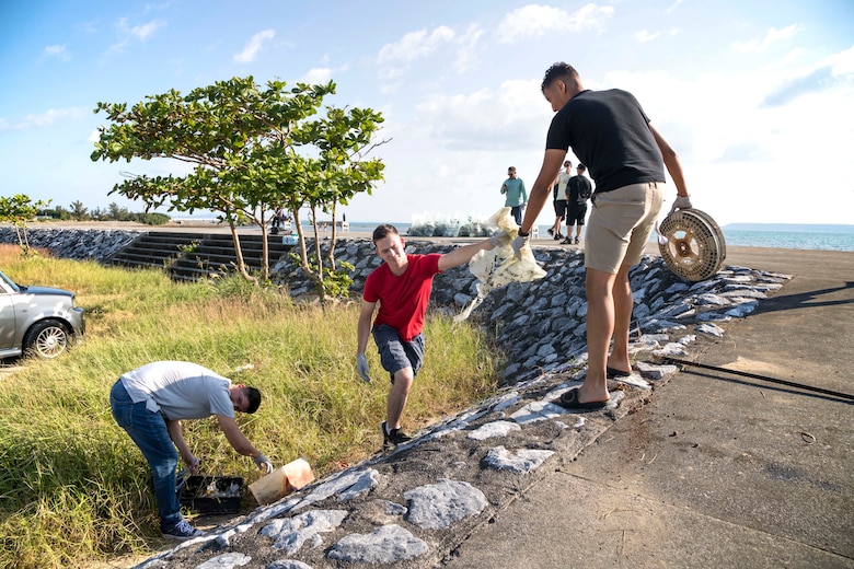 海岸線の清掃活動でゴミを拾い上げる海兵隊員。米海兵隊基地キャンプ・フォスターの海兵隊員ら約40人が、具志川ビーチで清掃活動を繰り広げました。