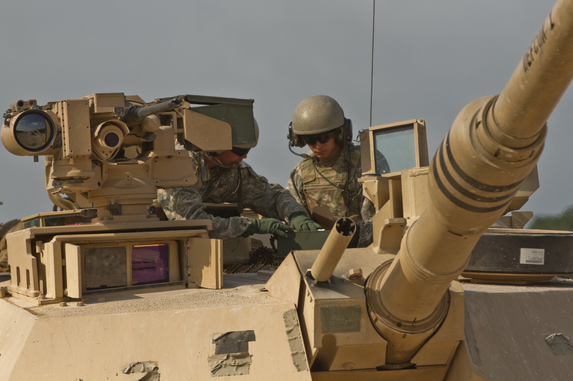 Crewman atop a tank converse.