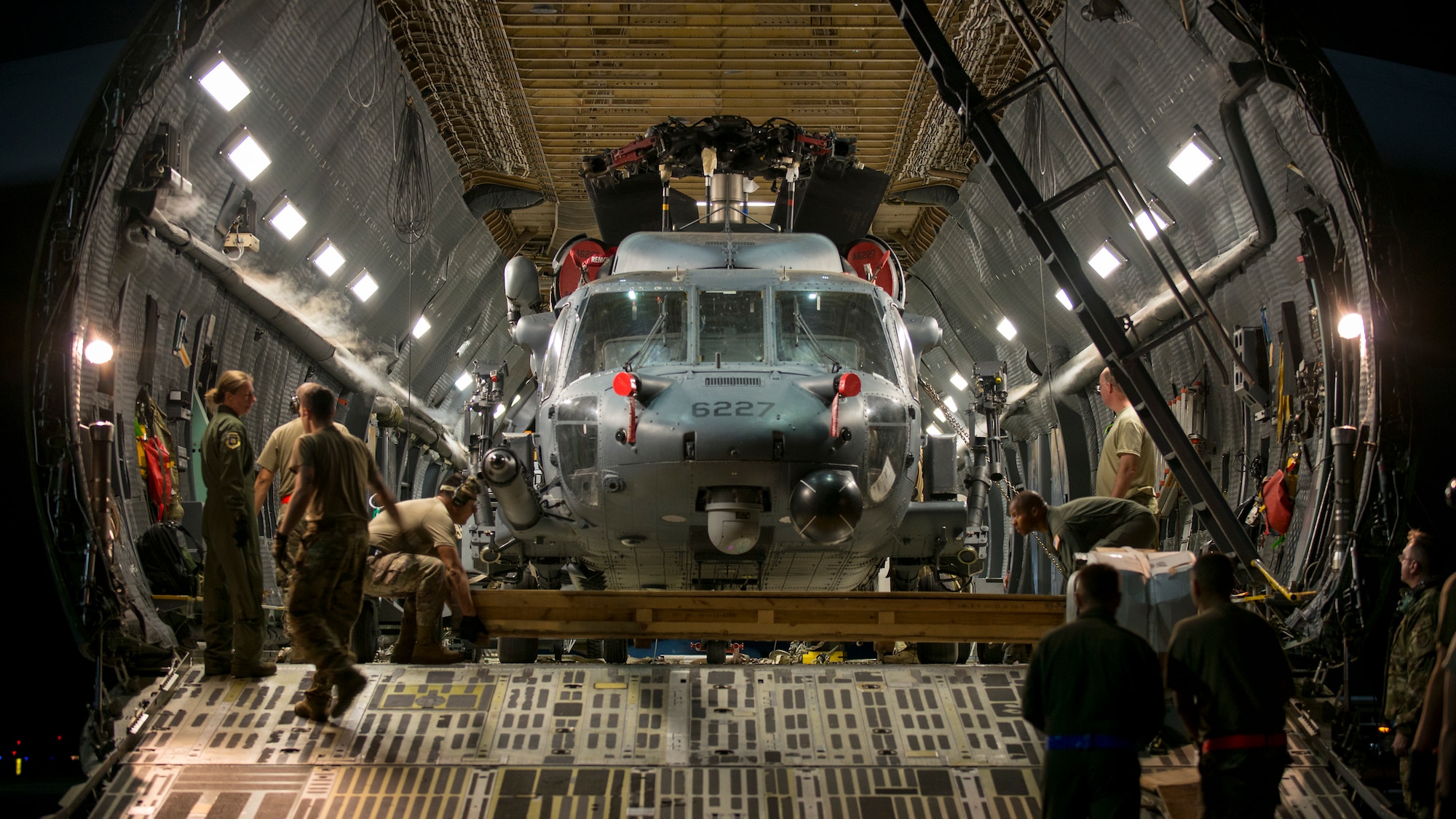Aircrew prepare to unload an HH-60 Pave Hawk helicopter assigned to the 305th Rescue Squadron, Davis-Monthan Air Force Base, Ariz., from a C-5 Super Galaxy assigned to the 512th Airlift Wing, Dover Air Force Base, Del., at MacDill Air Force Base, Fla., Nov. 6, 2019.