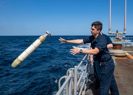 GULF OF OMAN (Nov. 7, 2019) Sonar Technician (Surface) Seaman Apprentice Isaiah Garcia deploys a MK 39 EMATT (Expendable Mobile ASW Training Target) from the fantail of the guided-missile cruiser USS Normandy (CG 60) as part of an anti-submarine warfare exercise during International Maritime Exercise 2019 (IMX 19).
