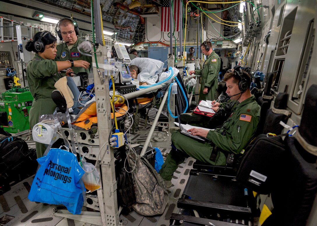 Critical care air transport teams and aeromedical evacuation teams provide medical care and attention to patients onboard a C-17 Globemaster III from Travis Air Force Base, Calif., after leaving Joint Base Pearl Harbor-Hickam, Hawaii, May 18, 2018. The C-17 was configured by an AE aircrew to provide aerial transport of patients throughout the Pacific region. (U.S. Air Force photo by Lan Kim)