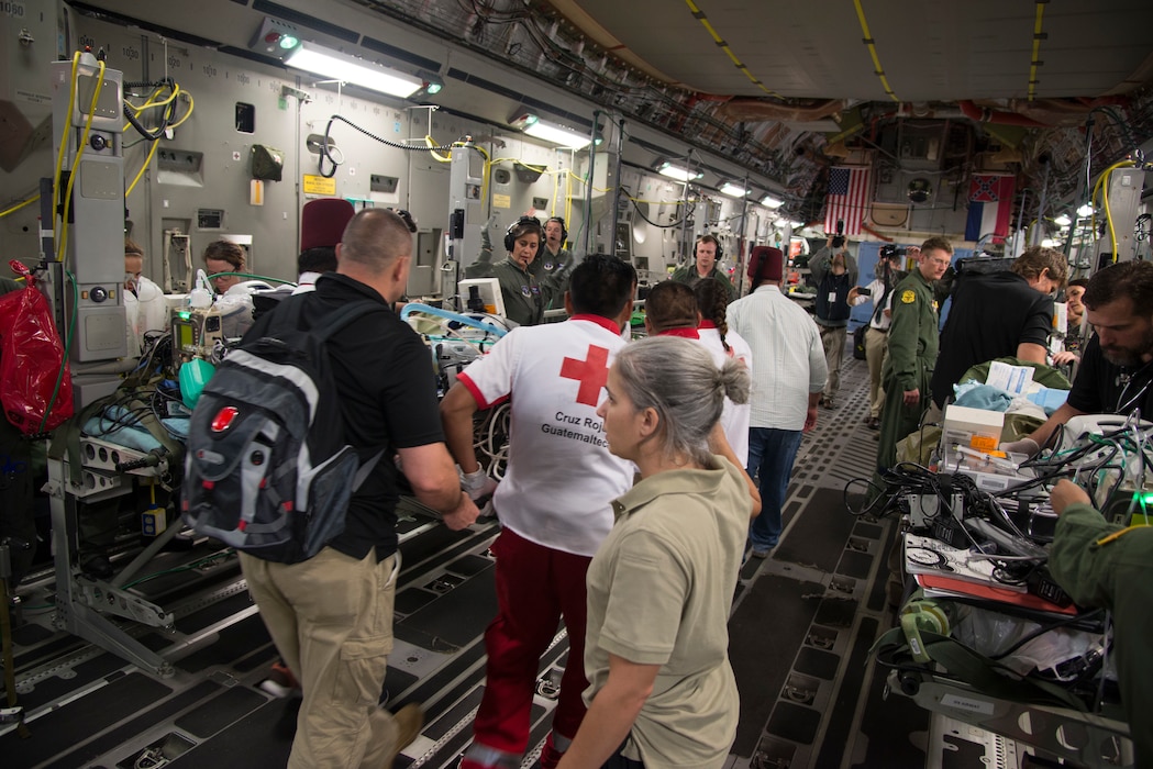 U.S. Army Maj. Julie Rizzo, center, burn surgeon and team lead from San Antonio Military Medical Center in Joint Base San Antonio, Texas, directs personnel while loading patients onto an Air Force C-17 Globemaster III during a humanitarian mission, June 6, 2018. The C-17 Globemaser III aircrew from the Mississippi Air National Guard's 172nd Airlift Wing, transported six children from Guatemala to receive medical treatment in Galveston, Texas, for burns and other injuries sustained during the recent Fuego Volcano eruption, which started June 3. (U.S. Air Force photo by Master Sgt. Keyonna Fennell)