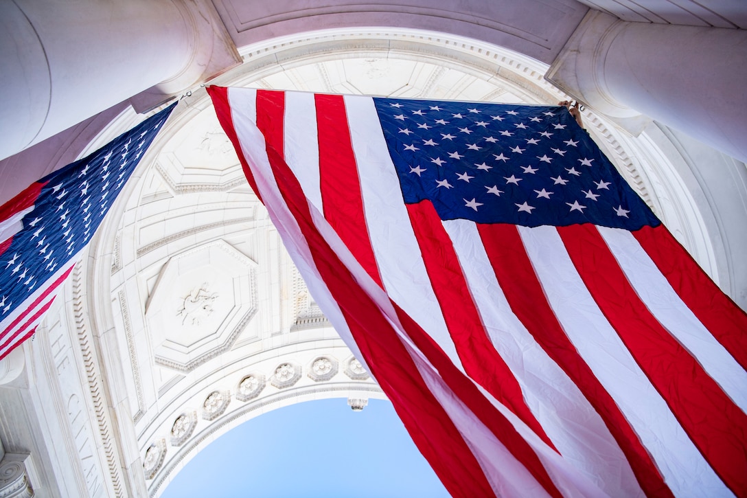 American flags hang from an ornate white archway.