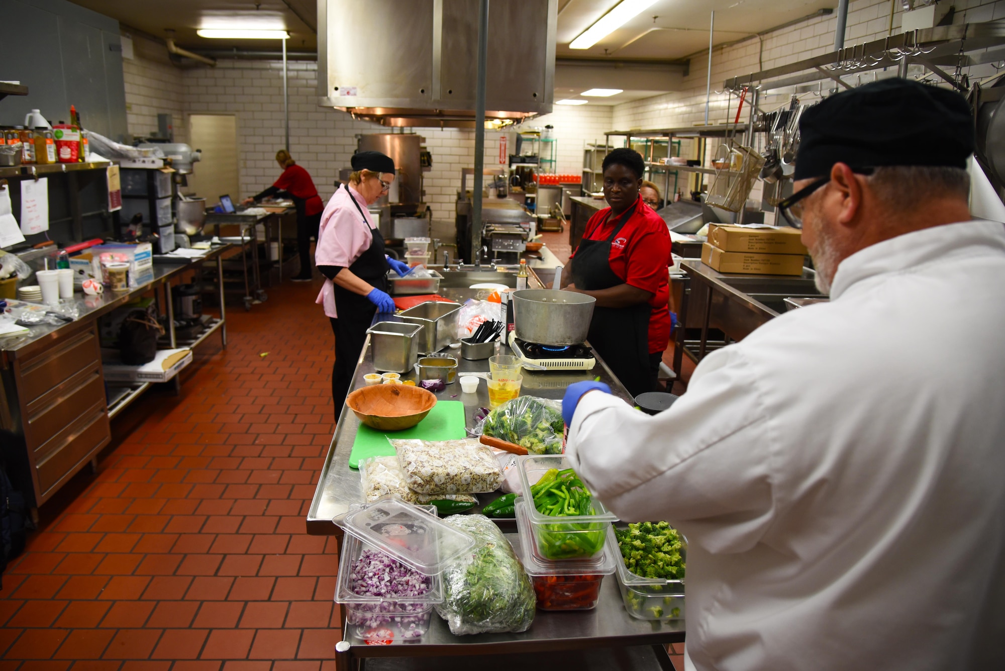 Chef Jeffery Yager, Air Force Services Center food and business operations specialist, and other cooks prepare food for the Club’s lunch rush Nov. 4, 2019, on Columbus Air Force Base, Miss. The Air Force Services Activity are helping Airmen across the Air Force obtain better fuel for body and brain health by rolling out new recipes. (U.S. Air Force photo by Airmen 1st Class Jake Jacobsen)
