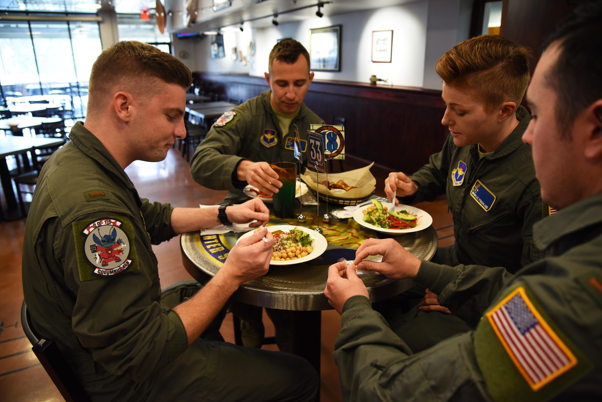 A group of student pilots eat lunch consisting of meals from the Club’s new menu Nov. 4, 2019, on Columbus Air Force Base, Miss. Columbus AFB was one of the test bases to train and push out the new dishes to the base populace for the Air Force’s healthy food initiative. (U.S. Air Force photo by Airmen 1st Class Jake Jacobsen)